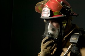 Fire fighter standing in uniform wearing face mask