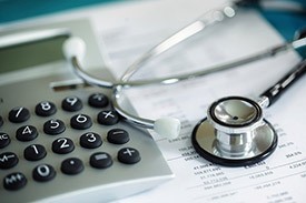 Stethoscope and calculator on paperwork